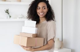 a woman holding cardboard boxes