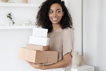 a woman holding cardboard boxes
