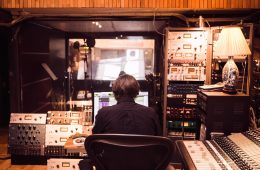 man in front of studio mixer and receiver