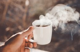 person holding white ceramic cup with hot coffee