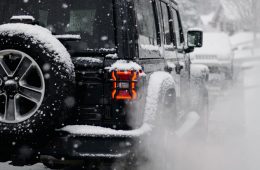 a jeep driving down a snow covered road